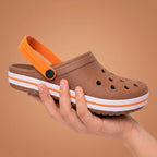 Chinelo marrom com detalhes laranja e sola branca, ideal para conforto e estilo casual.